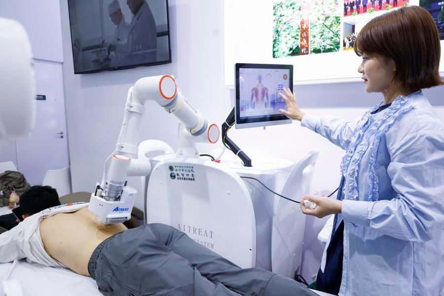 9일 '2026 CIFTIS' 내 건강·위생 서비스 특별 전시구역에서 스마트 추나 로봇을 시연하는 전시업체 관계자. (사진/신화통신)