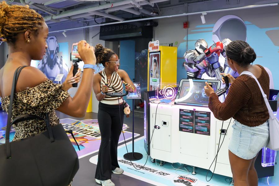 자메이카 관광객이 광둥(廣東)성 선전(深圳)시 룽강(龍崗)구에 있는 세계 최초의 로봇 6S(판매·부품·서비스·조사·맞춤 제작·임대) 매장에서 인터랙티브 게임을 하고 있다. (사진/신화통신)