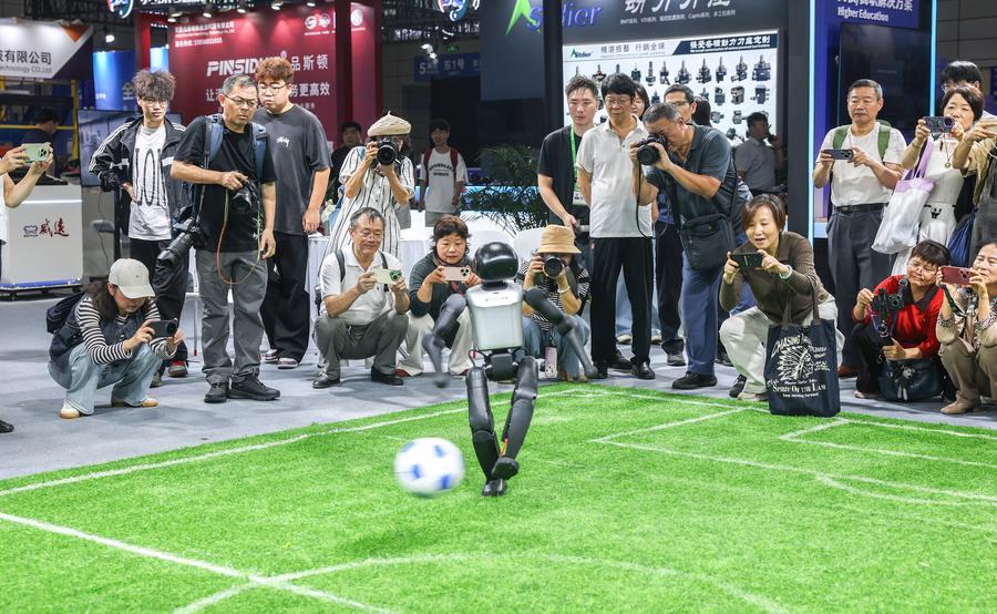 지난달 21일 '2026 세계제조업대회' 인공지능(AI) 및 로봇 전시홀의 한 전시 부스에서 로봇의 슈팅을 관람하는 내방객. (사진/신화통신)