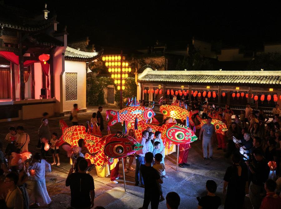 지난 1일 안후이(安徽)성 황산(黃山)시 이(黟)현의 한 마을에서 어등과 함께 사진을 찍는 관광객을 드론에 담았다. (사진/신화통신)